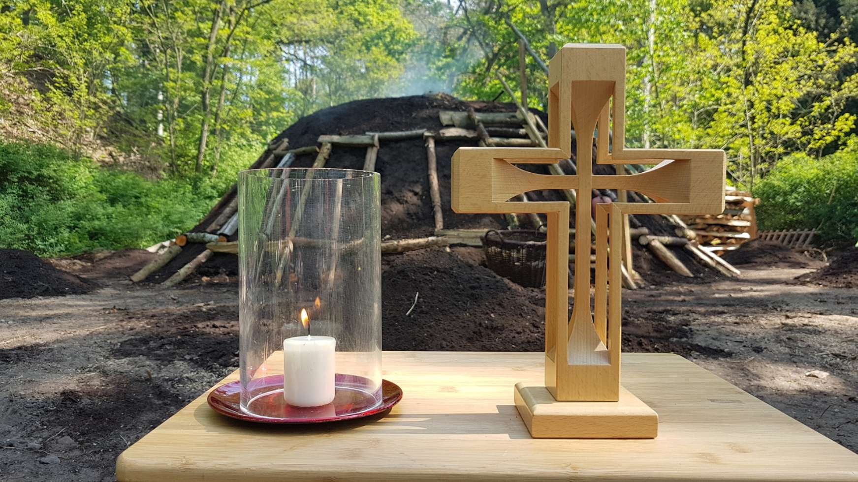 Der Holzkohlemeiler wird bei einem Waldgottesdienst gesegnet und schwelt anschließend ca. 10 Tage.